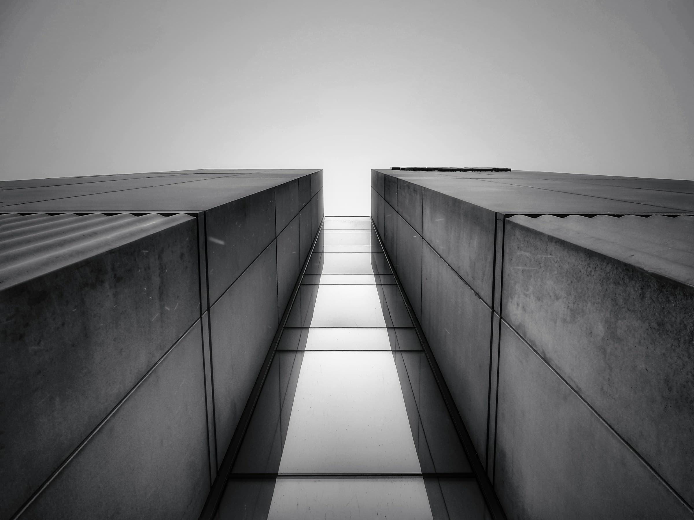 Two symmetrical towers viewed from below, seen from a narrow gap between them.