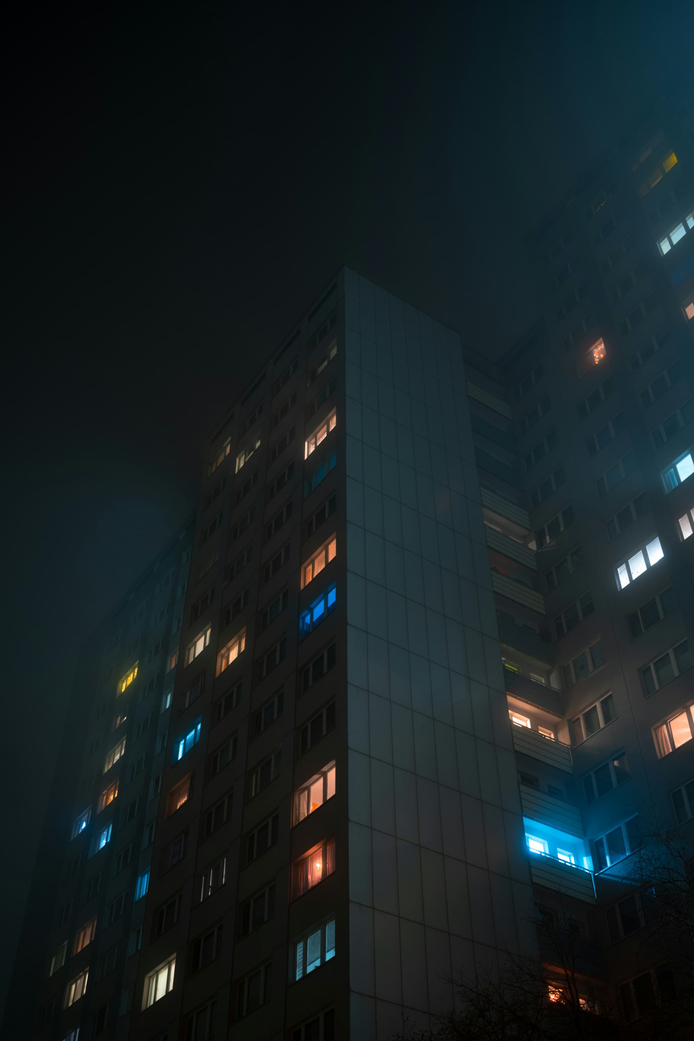 A residential tower lit from within at night in Berlin — illustrative.